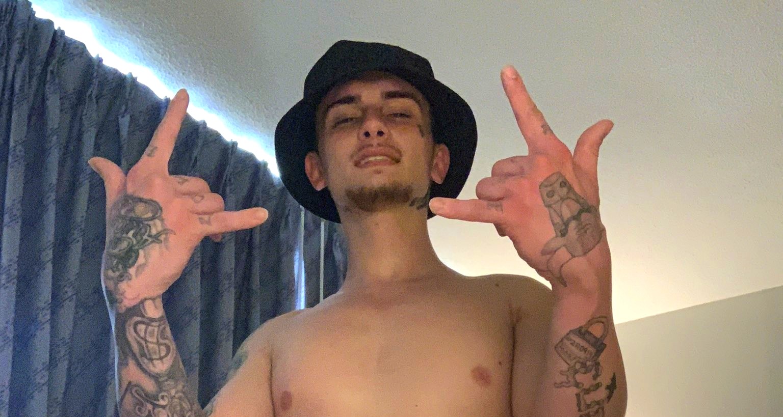 Trik in a bucket hat throwing up both hands
